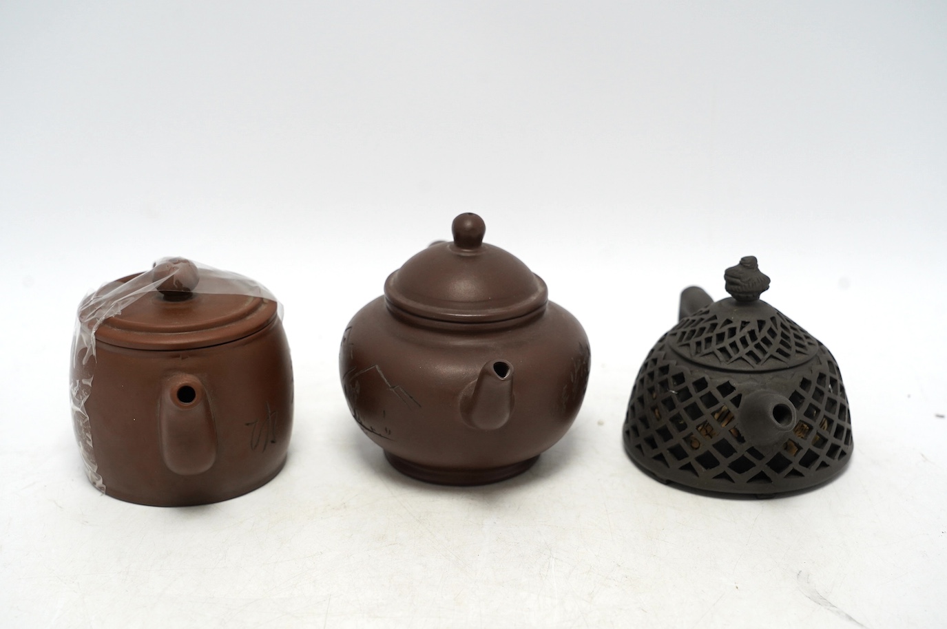 Three Yixing teapots, one double walled lattice worked body, tallest 11cm. Condition - good